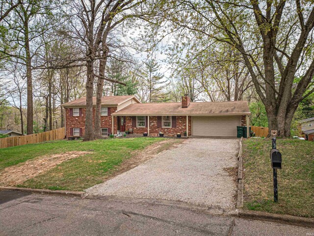 8013 Larch Ln, Evansville, IN 47710 - split level home featuring gravel driveway, a chimney, fence, brick siding, and a garage