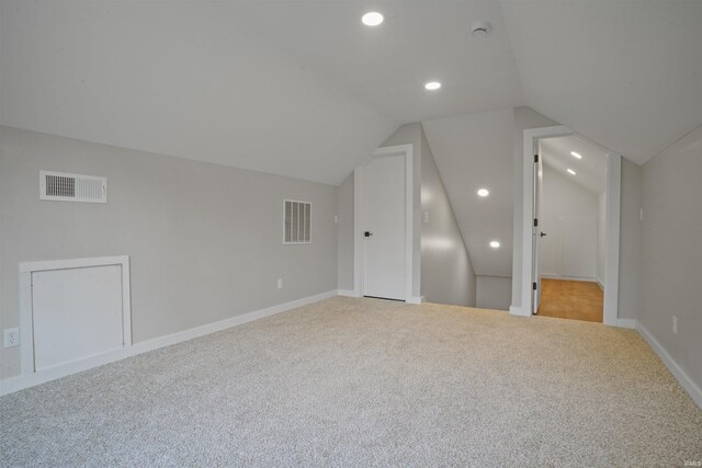 bonus room with carpet flooring, vaulted ceiling, and visible vents