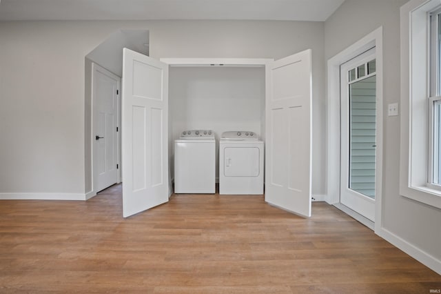laundry room with baseboards, laundry area, light wood-style flooring, and independent washer and dryer