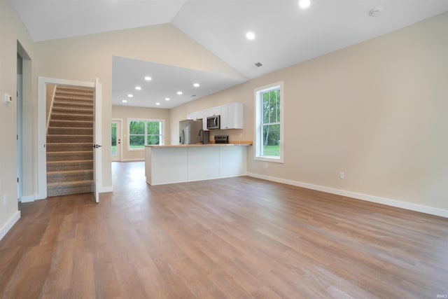 unfurnished living room with recessed lighting, light wood-type flooring, stairs, and visible vents