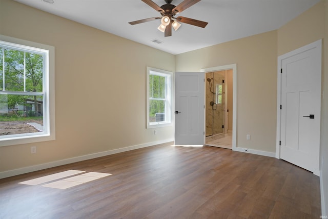 unfurnished bedroom featuring baseboards, wood finished floors, and visible vents