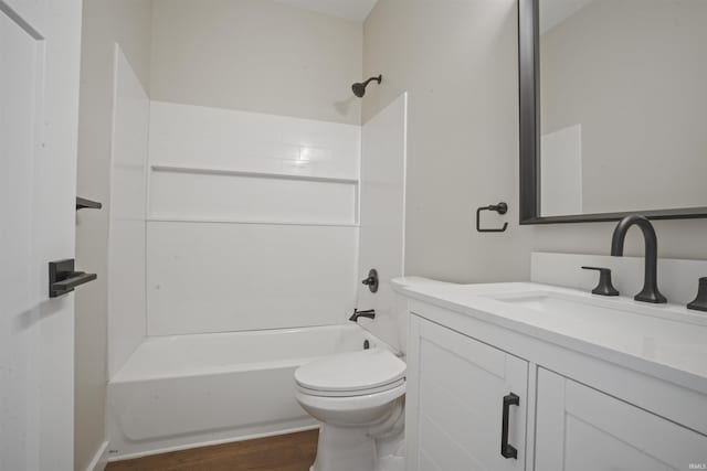 bathroom featuring toilet, tub / shower combination, wood finished floors, and vanity