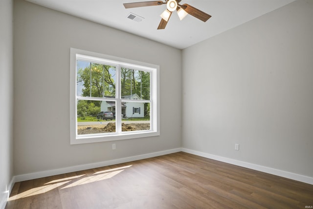 unfurnished room featuring visible vents, baseboards, ceiling fan, and wood finished floors