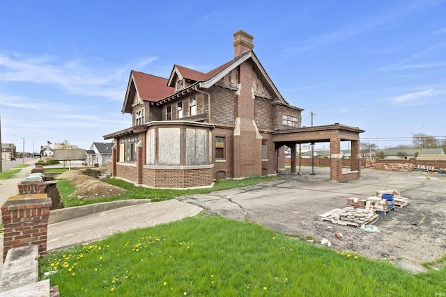 view of side of home featuring a chimney and brick siding