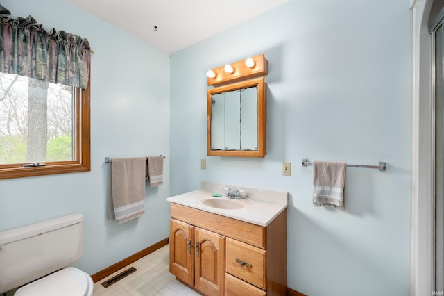 bathroom featuring tile patterned floors, toilet, baseboards, visible vents, and vanity