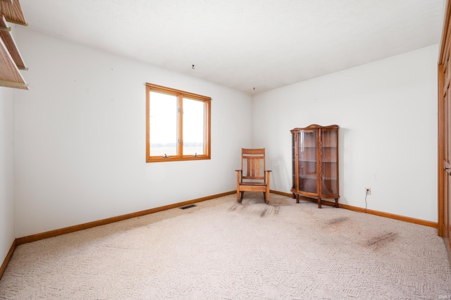 unfurnished room featuring baseboards, carpet flooring, and visible vents