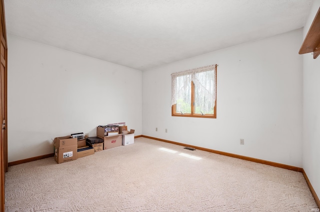 empty room with visible vents, carpet flooring, and baseboards