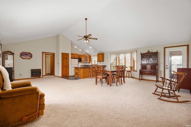 dining room featuring a ceiling fan, heating unit, a wealth of natural light, light colored carpet, and baseboards