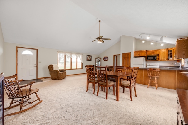 dining space with light colored carpet, baseboards, a ceiling fan, and high vaulted ceiling