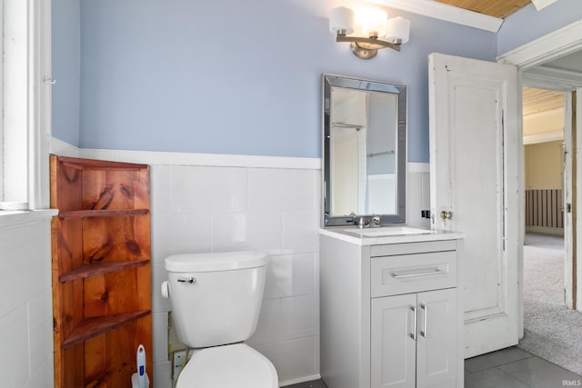 bathroom featuring tile patterned floors, a wainscoted wall, vanity, and toilet