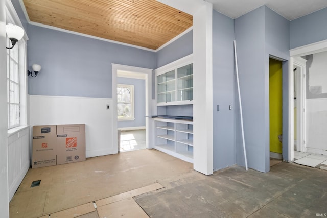 empty room featuring wood ceiling and ornamental molding