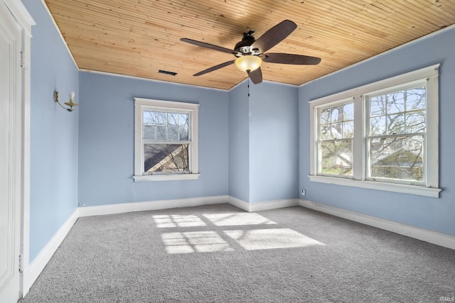 carpeted spare room featuring wooden ceiling, baseboards, and ceiling fan