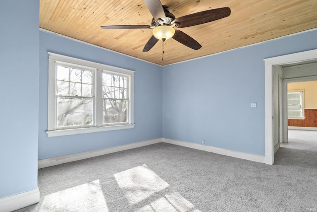 spare room with wood ceiling, ceiling fan, a wealth of natural light, and carpet