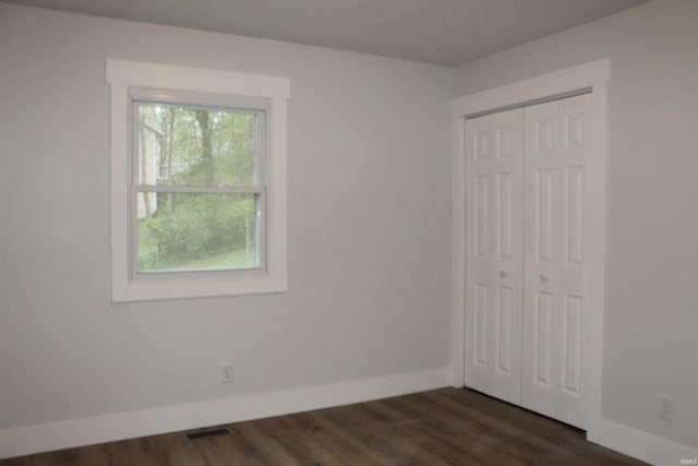 320 W Ritter St, Ellettsville, IN 47429 - unfurnished bedroom with visible vents, dark wood-type flooring, baseboards, and a closet