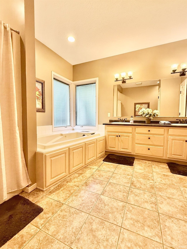 full bath with a garden tub, tile patterned flooring, a sink, and double vanity