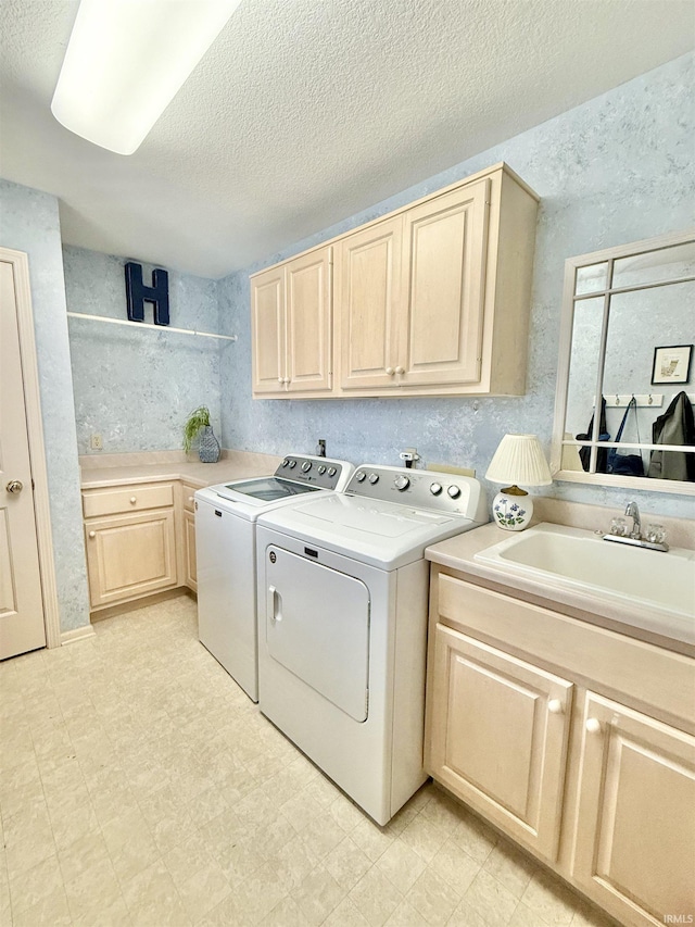 laundry room with light floors, a sink, separate washer and dryer, cabinet space, and a textured ceiling