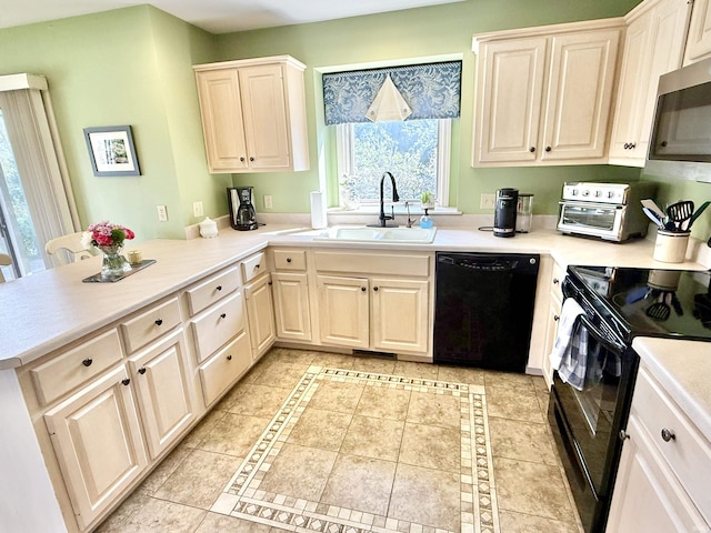 kitchen featuring a peninsula, a sink, black appliances, light countertops, and light tile patterned floors