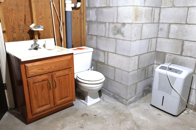 12176 E 350 N, Loogootee, IN 47553 - bathroom with unfinished concrete flooring, toilet, vanity, and concrete block wall