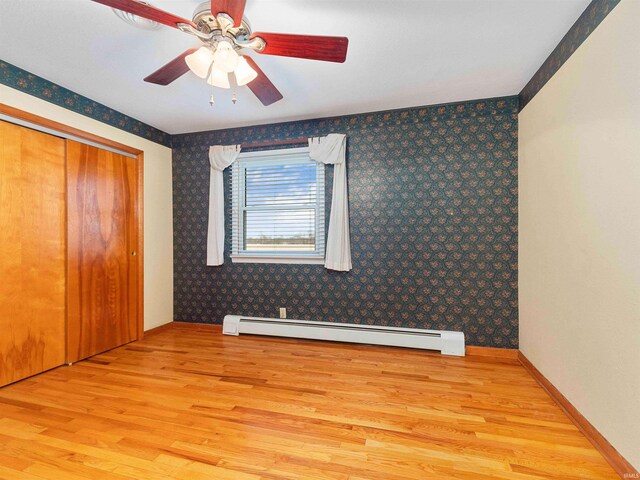 2801 W 700 S, Claypool, IN 46510 - unfurnished bedroom with a baseboard heating unit, wallpapered walls, light wood-style floors, and baseboards