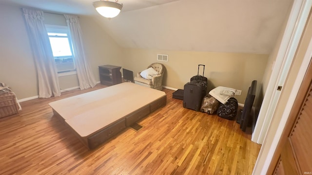 interior space with baseboards, visible vents, lofted ceiling, and light wood-style flooring
