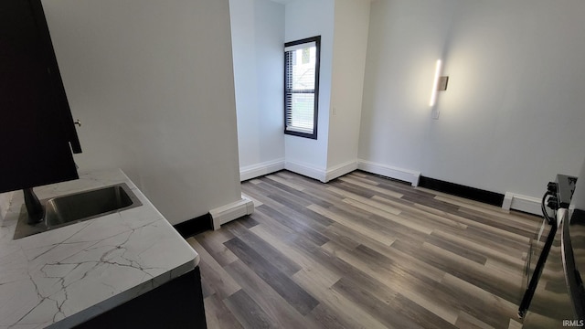 interior space with visible vents, baseboards, wood finished floors, and a sink