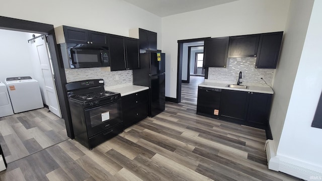 kitchen with dark cabinetry, washer and clothes dryer, black appliances, and tasteful backsplash