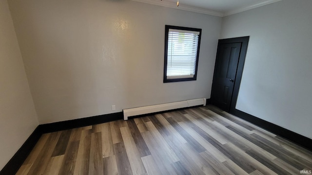 unfurnished room with a baseboard heating unit, baseboards, crown molding, and wood finished floors