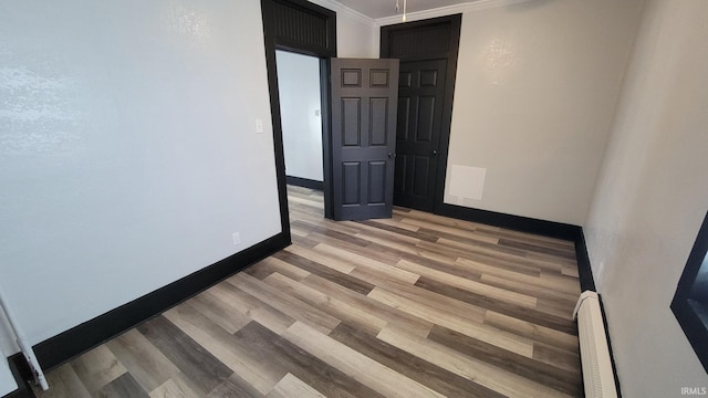 unfurnished room with light wood-style floors, visible vents, baseboards, and ornamental molding