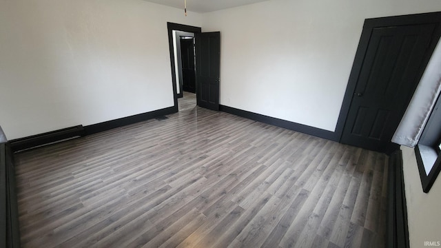 unfurnished room featuring baseboards and wood finished floors