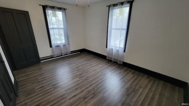 unfurnished bedroom featuring baseboards and dark wood-style flooring
