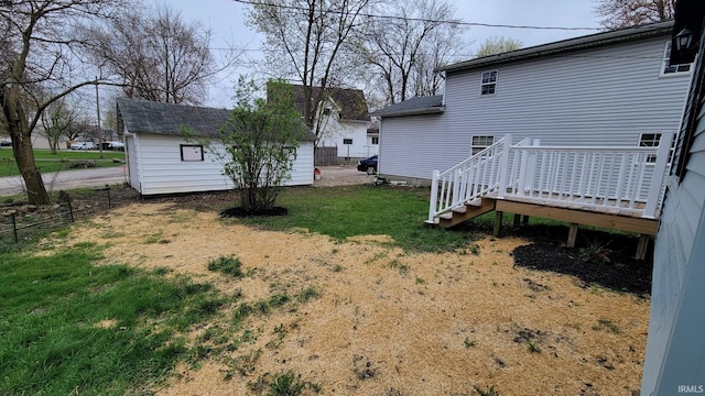view of yard featuring a wooden deck, fence, stairs, and an outdoor structure