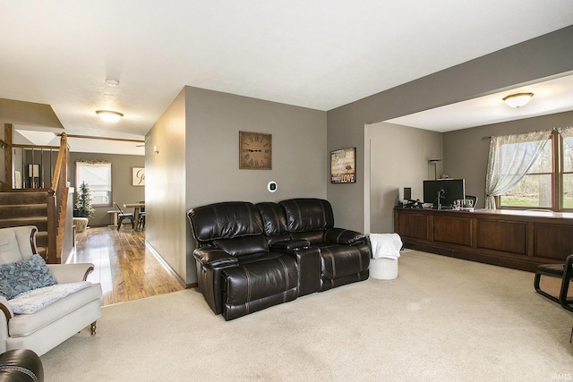 living area with stairway and light colored carpet