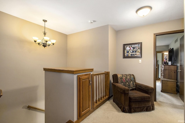 living area featuring an inviting chandelier, visible vents, light colored carpet, and an upstairs landing