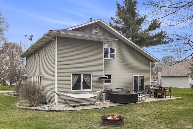 rear view of house featuring a lawn, an outdoor living space with a fire pit, and a patio