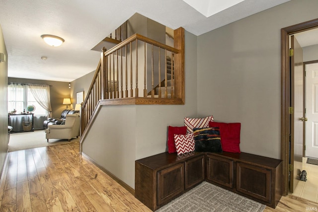 stairs with wood finished floors and baseboards