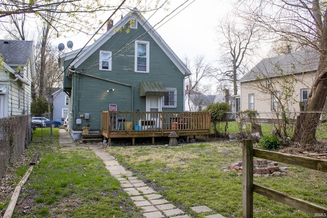 rear view of property featuring a wooden deck, fence, and a yard