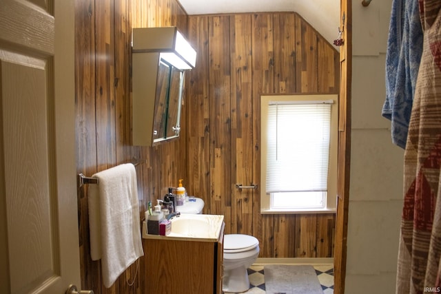 bathroom featuring tile patterned floors, wood walls, vanity, and toilet