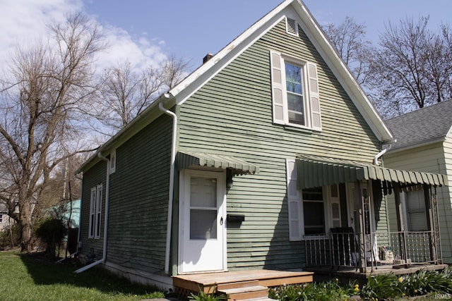 exterior space featuring covered porch and a yard