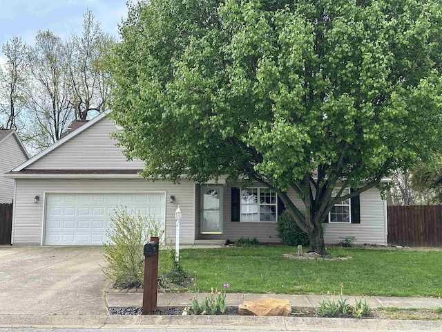 view of property hidden behind natural elements featuring a front lawn, an attached garage, concrete driveway, and fence