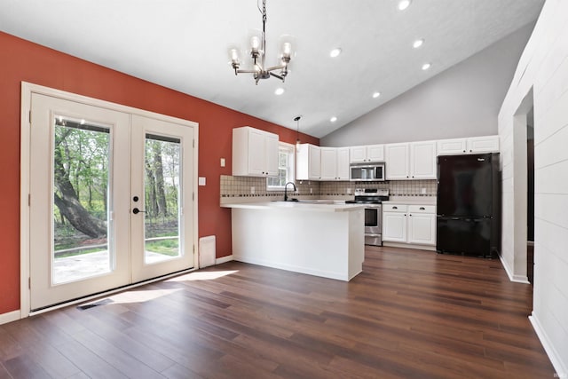 kitchen with recessed lighting, french doors, a peninsula, a chandelier, and appliances with stainless steel finishes