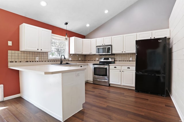 kitchen featuring white cabinets, stainless steel appliances, a peninsula, and a sink