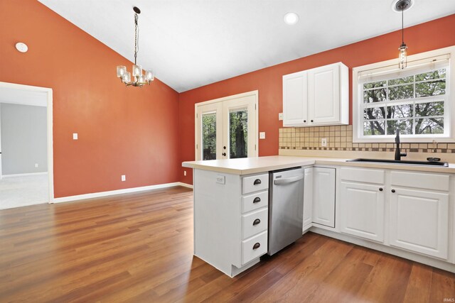 kitchen featuring a peninsula, stainless steel dishwasher, a sink, light wood-style floors, and lofted ceiling