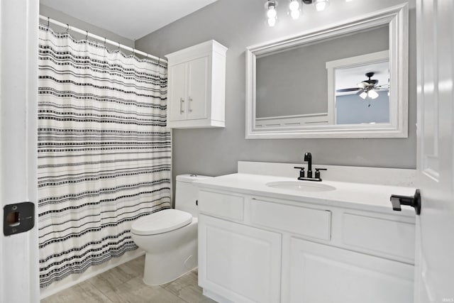 full bath with toilet, a ceiling fan, vanity, and a shower with shower curtain