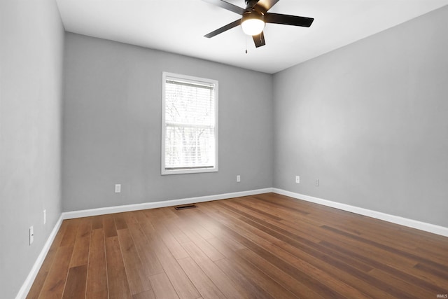 unfurnished room with wood finished floors, baseboards, a ceiling fan, and visible vents