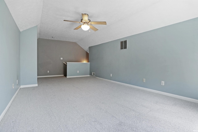 additional living space featuring vaulted ceiling, a ceiling fan, baseboards, carpet flooring, and visible vents