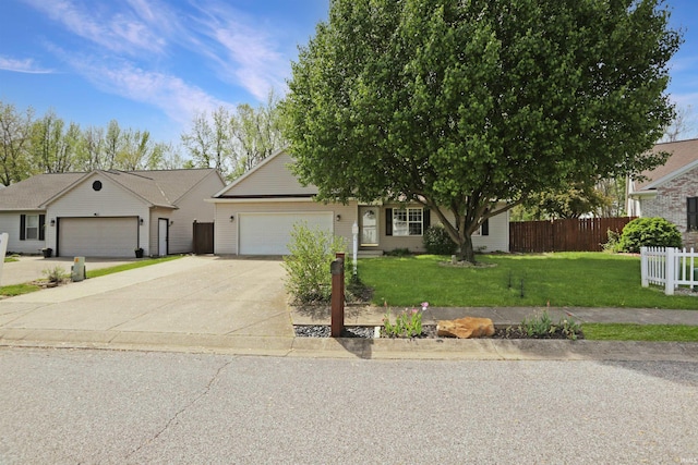 view of front of home with an attached garage, fence, driveway, and a front lawn