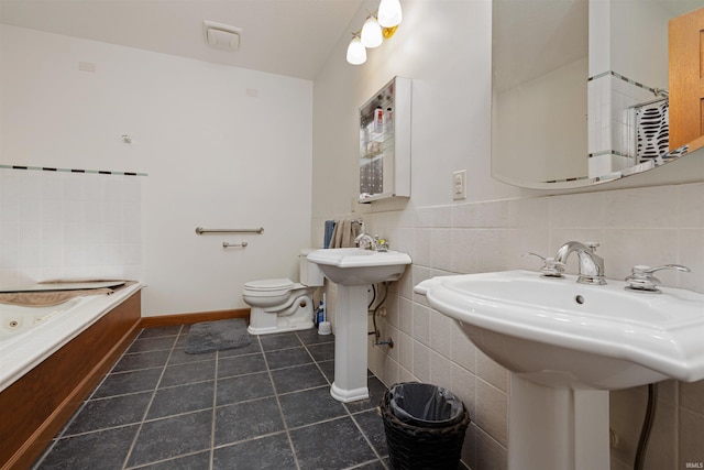 bathroom featuring a garden tub, tile patterned flooring, and toilet