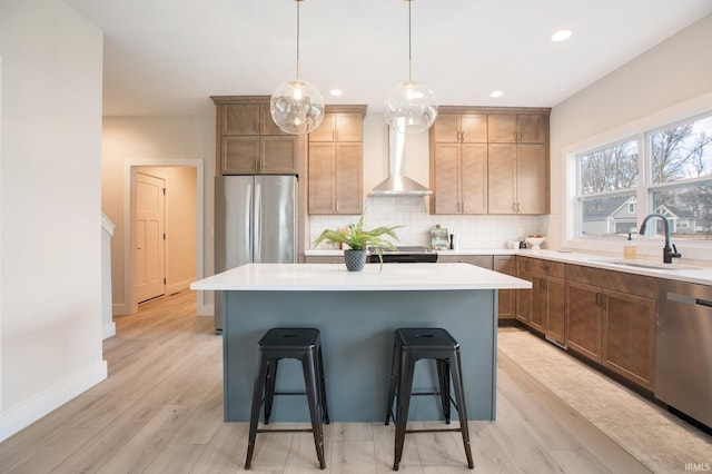 12793 Brick Rd Lot 4, Granger, IN 46530 - kitchen featuring a breakfast bar, a sink, light wood-style floors, wall chimney exhaust hood, and appliances with stainless steel finishes