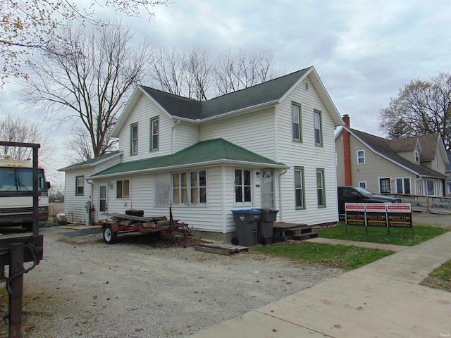view of front facade with roof with shingles