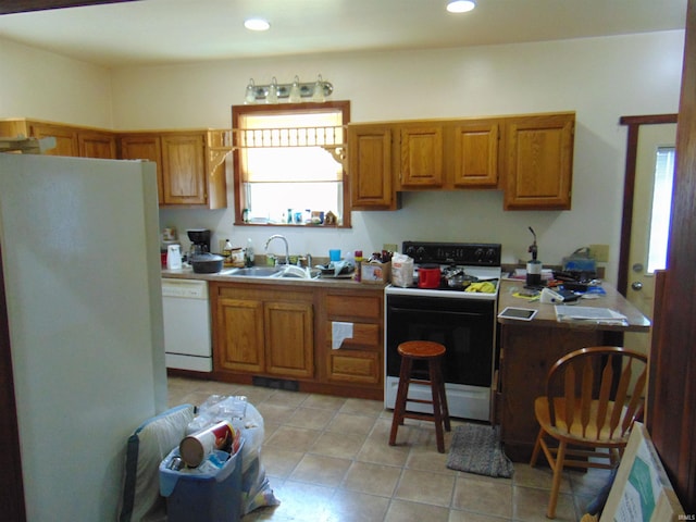 kitchen with light tile patterned flooring, a sink, white appliances, and plenty of natural light